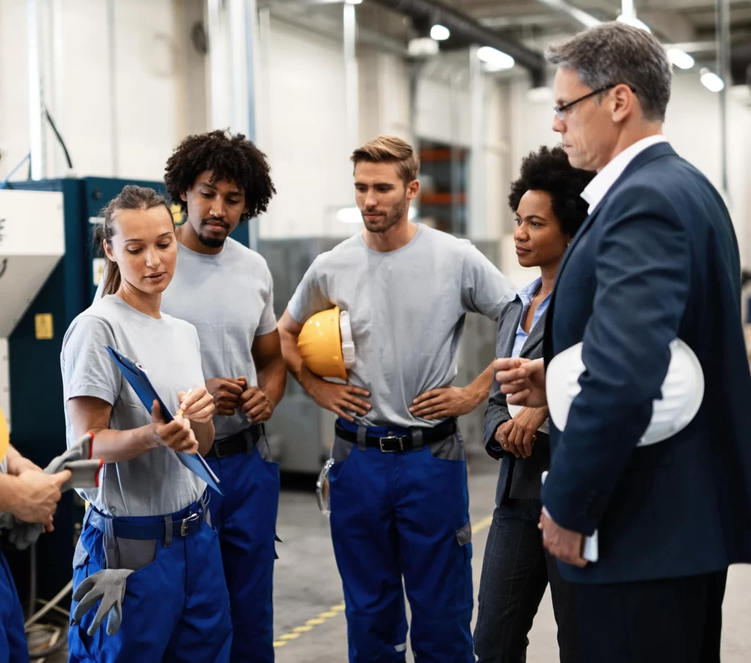 group-workers-having-meeting-with-company-managers-factory-focus-is-female-worker-is-presenting-development-reports-min